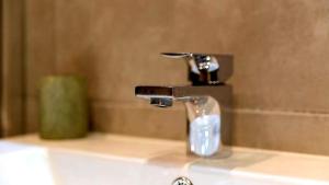 a bathroom sink with a faucet and a bottle of soap at Unique Victorian Home in Glasgow in Glasgow