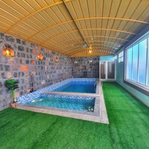 a swimming pool in a house with a green lawn at alreaambreather2 in Sayq