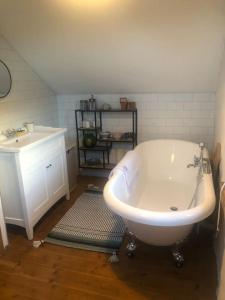 a bathroom with a white tub and a sink at Hopesgate Cottage - Roscrea in Roscrea