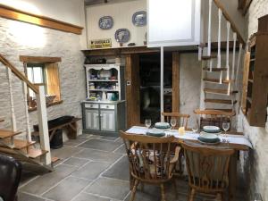 une cuisine avec une table et des chaises ainsi qu'un escalier dans l'établissement Hopesgate Cottage - Roscrea, à Roscrea