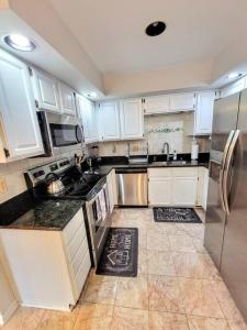 a kitchen with white cabinets and stainless steel appliances at Awesome Home in suburb Washington DC near Airport with WiFi and Parking in Herndon