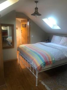 a bedroom with a bed with a colorful blanket at Hopesgate Cottage - Roscrea in Roscrea