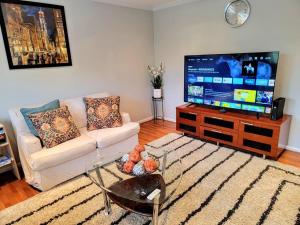a living room with a couch and a flat screen tv at Awesome Home in suburb Washington DC near Airport with WiFi and Parking in Herndon