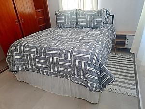 a bed with a black and white blanket and pillows at Un punto- 2 Bedroom Apartment in San Miguel de Allende