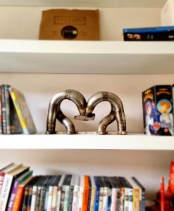 a faucet in a shelf with books at Unique Victorian Home in Glasgow in Glasgow