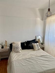Un dormitorio con una cama grande con almohadas. en 2 amb a la calle La Perla en Mar del Plata