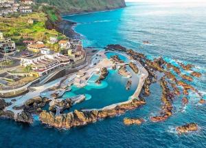 an aerial view of a resort in the ocean at Apartamento T2-5m Aeroporto CR7 in Santa Cruz