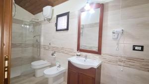 La salle de bains est pourvue d'un lavabo, de toilettes et d'un miroir. dans l'établissement Camera matrimoniale 1 per vacanza al mare VILLA FRANCA, à Cariati