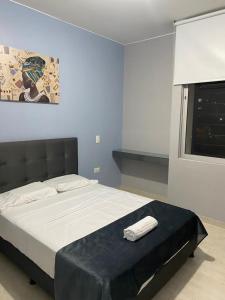 1 dormitorio con 1 cama grande y pared azul en Apartamento en exclusivo sector de la ciudad, en Los Patios