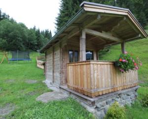 een kleine houten hut in een veld met bloemen bij Alpboden in Auffach