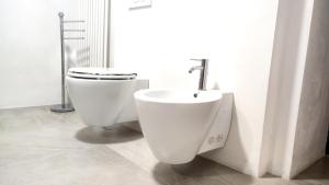a bathroom with a toilet and a sink at Ikuvium Home in Gubbio