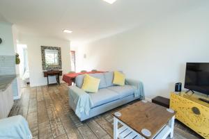 un soggiorno con divano blu e tavolo di Harbour View - Gqeberha - Two bed apartment a South End