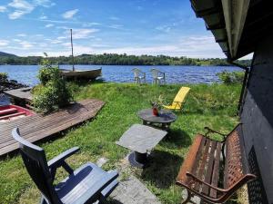 um grupo de cadeiras, uma mesa de piquenique e um lago em Small Basement Apartment Private Entrance Nice View em Fitjar