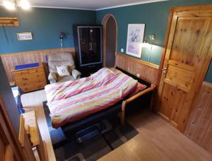 1 dormitorio pequeño con 1 cama y 1 silla en Small Basement Apartment Private Entrance Nice View, en Fitjar