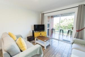 un soggiorno con divano e TV di Harbour View - Gqeberha - Two bed apartment a South End