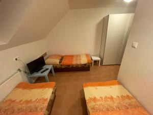 a room with two beds and a desk with a laptop at penzión Brooklyn in Skalica