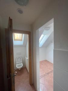 an attic bathroom with a toilet and a window at penzión Brooklyn in Skalica