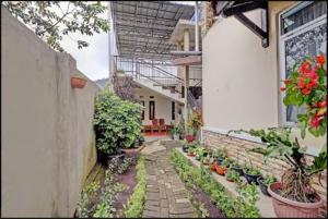 un patio con macetas y un edificio en Adinda Homestay Lembang, en Lembang