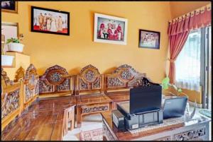 a living room with a couch and a television at Adinda Homestay Lembang in Lembang