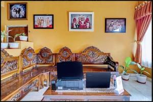 a living room with a table with a laptop on it at Adinda Homestay Lembang in Lembang