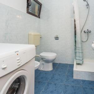 a bathroom with a toilet and a washing machine at Joso Dalmatia in Vir