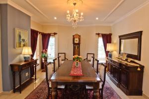 una sala da pranzo con tavolo e orologio di Villa Toledo a Pretoria
