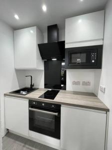 uma cozinha com um fogão e um micro-ondas em Premier 1 Bed Studio B em Broxburn