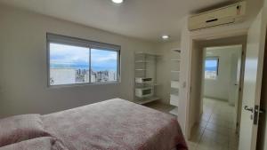 フロリアノポリスにあるApartamento Alto Padrão - Vista Panorâmicaのベッドルーム(ベッド1台、窓付)