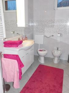 a white bathroom with a sink and a toilet at Apartman Braja in Virovitica