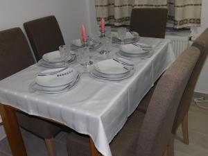 einen Tisch mit Tellern, Gläsern und Kerzen darauf in der Unterkunft Apartman Braja in Virovitica
