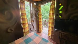 a living room with a tv and a room with windows at Casita de Duendes in Salinas 