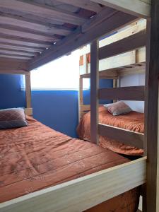 2 literas en un dormitorio con paredes azules en Casa de la Ribera Pelantaro, en Valdivia