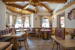 restauracja ze stołami, krzesłami i oknami w obiekcie Hotel-Restaurant Burgblick w mieście Dorfgastein