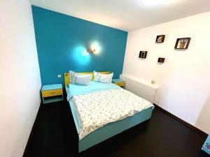 - une chambre dotée d'un lit avec un mur bleu dans l'établissement Casa De Sub Padure, à Bran