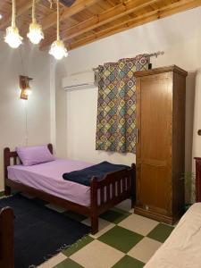 1 dormitorio con 1 cama y armario de madera en Moon el mashraba, en Dahab
