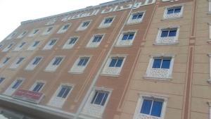 fachada de un edificio con ventanas blancas en شقق مساكن الراية المخدومه en Al Khobar