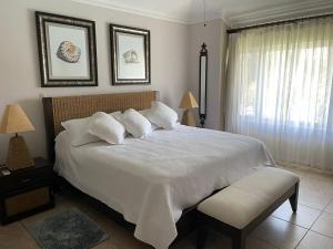 una camera da letto con un grande letto bianco e una finestra di 2 Bedroom Penthouse, Ocean Dream, Cabarete a Cabarete Altre 17 foto