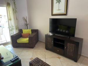 un soggiorno con TV a schermo piatto su un centro di intrattenimento di 2 Bedroom Penthouse, Ocean Dream, Cabarete a Cabarete