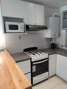 una cucina con fornelli e microonde di Pina a Mar del Plata