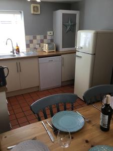 uma cozinha com uma mesa de madeira e um frigorífico em Beautiful mews cottage. Ledbury town centre. em Ledbury