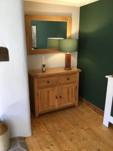 een kamer met een houten dressoir en een spiegel bij Beautiful mews cottage. Ledbury town centre. in Ledbury