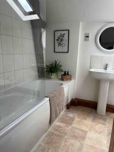 y baño con bañera y lavamanos. en Beautiful mews cottage. Ledbury town centre. en Ledbury