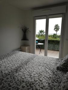 a bedroom with a bed and a view of a patio at Antibes T2 Vue mer 48m2 Terrasse Parking Piscine Plage in Antibes