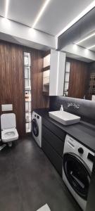 La salle de bains est pourvue d'un lavabo et d'un lave-linge. dans l'établissement Oasis Luxury Apartments, à Chişinău
