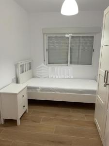 a white bedroom with a bed and a window at UIM Mediterraneo Conqueridor Wifi in Sagunto