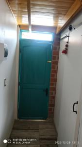 una puerta verde en una habitación con una pared de ladrillo en Loft para 2 en concón, en Concón