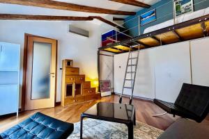 een woonkamer met een bank en een hoogslaper bij Al Rifugio del Velista in Trieste
