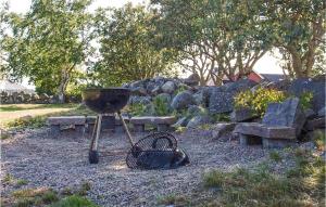 a grill with a basket and benches in a park at 1 Bedroom Lovely Home In Falkenberg in Falkenberg +8 photos