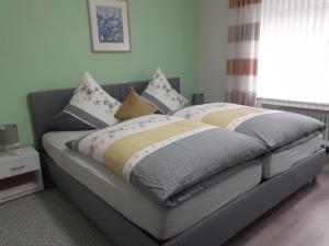 Un dormitorio con una cama grande con almohadas. en Nähe Nürburgring in Quiddelbach, Gästezimmer mit Lounge, en Quiddelbach