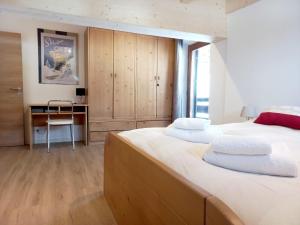 a bedroom with two beds and a desk in it at Chalet Relax in Pozza di Fassa